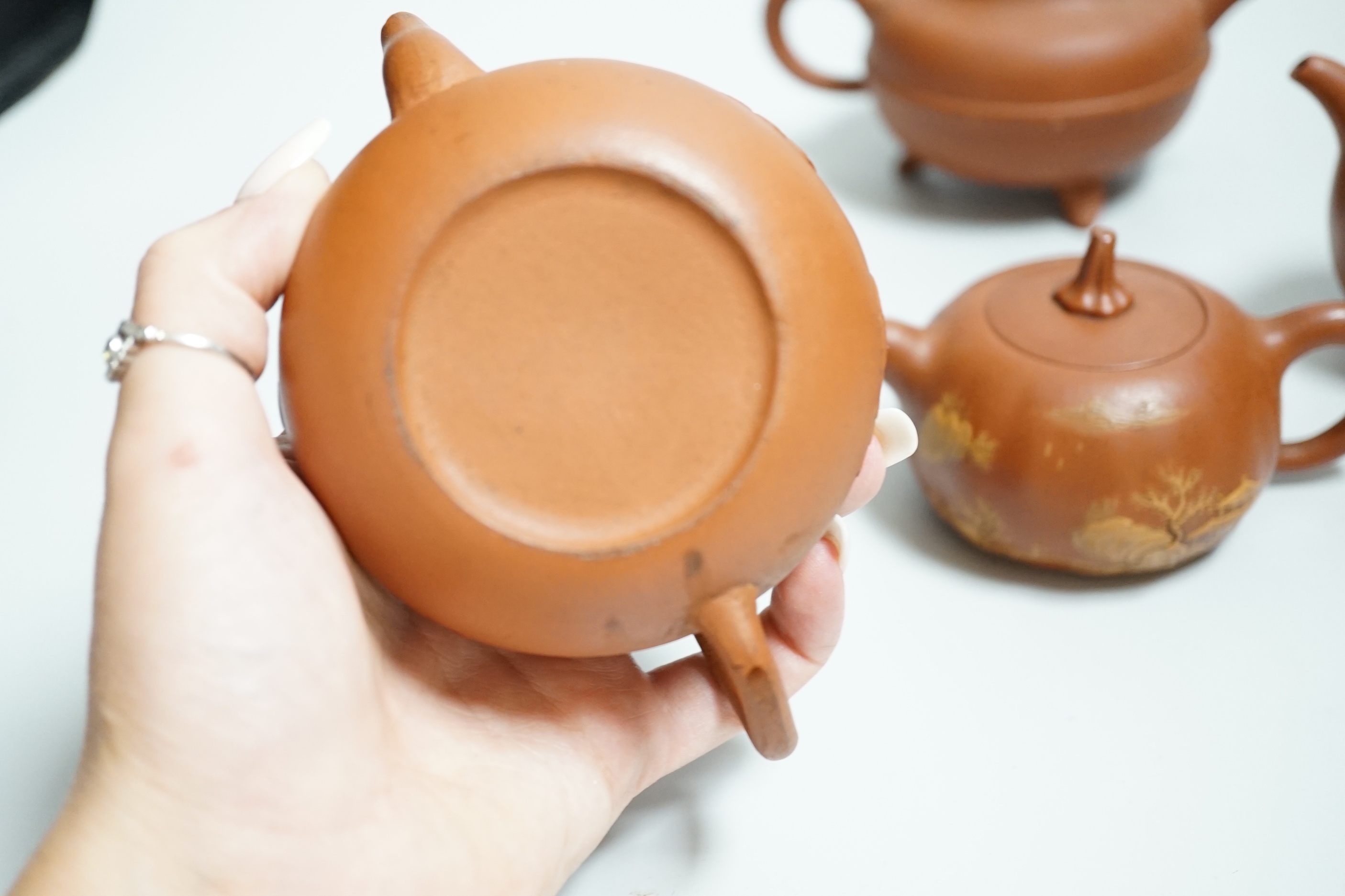 Four Chinese Yixing teapots, one slip decorated with a landscape